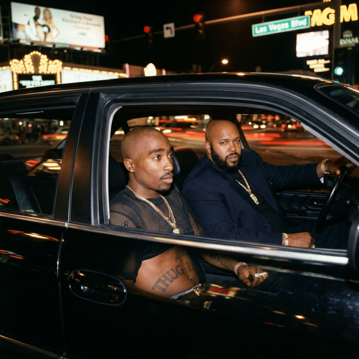 Two men seated in a car on Las Vegas Boulevard at night