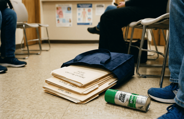 Clinic waiting room with tote bag, case files, and spray can on floor